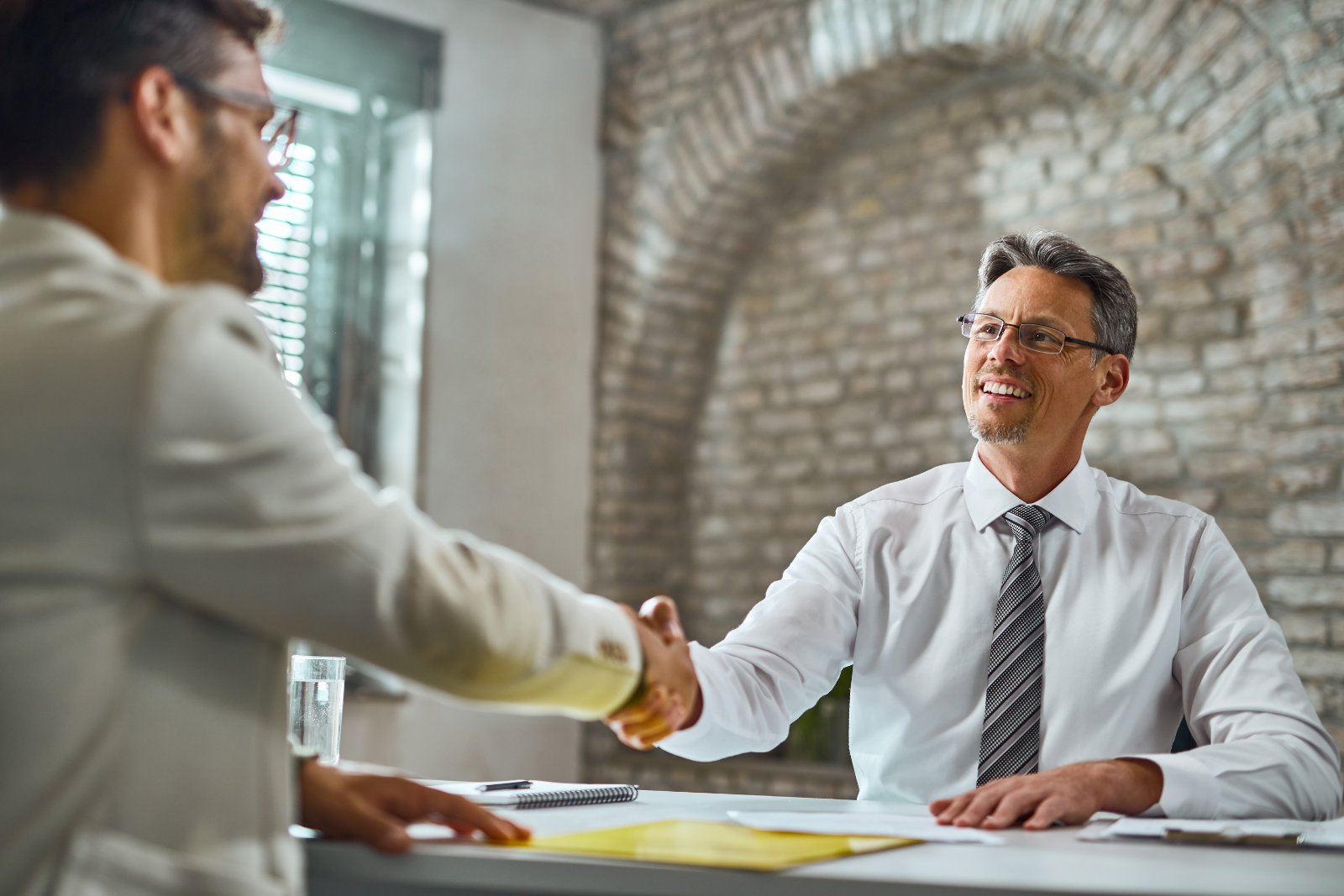 Colloquio di lavoro in ufficio Stretta di mano tra selezionatore e candidato al termine di un colloquio di lavoro in ufficio
